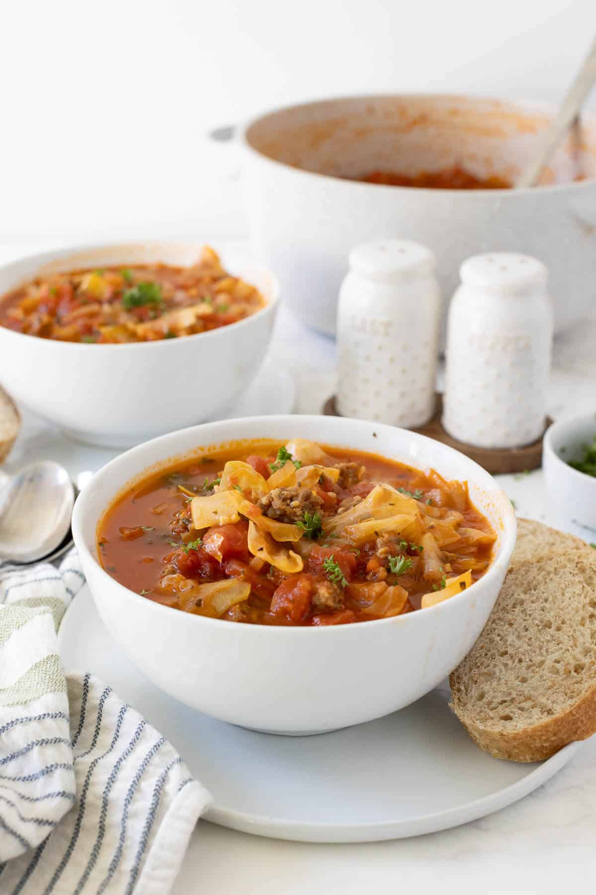 Sausage and Cabbage Soup in a white bowl.