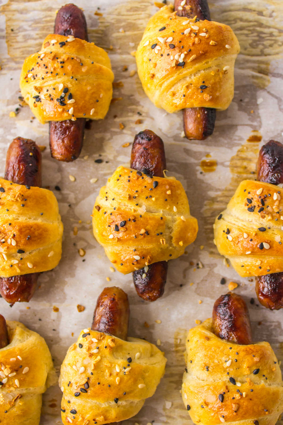 Breakfast pigs in a blanket on a baking sheet.