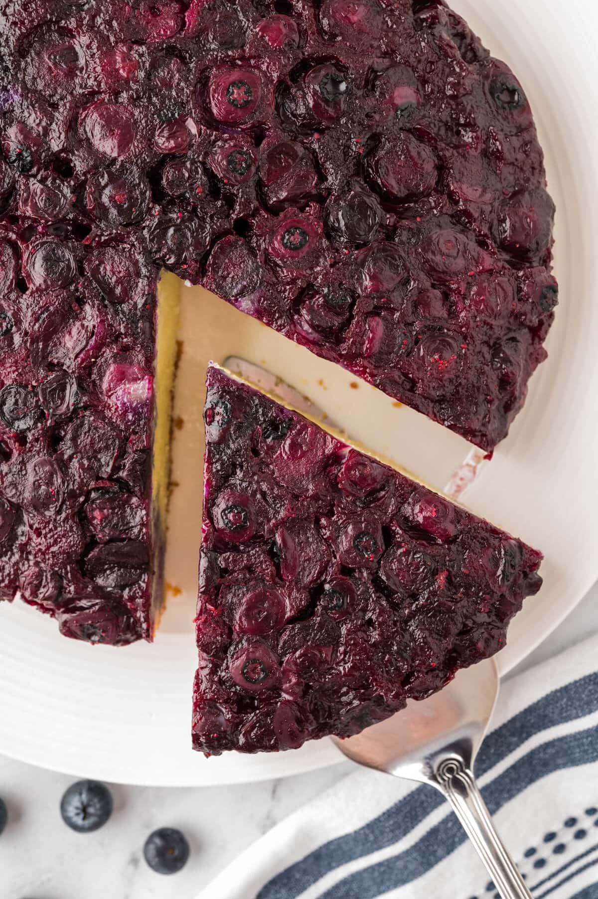 A slice of blueberry upside down cake on a spatula.