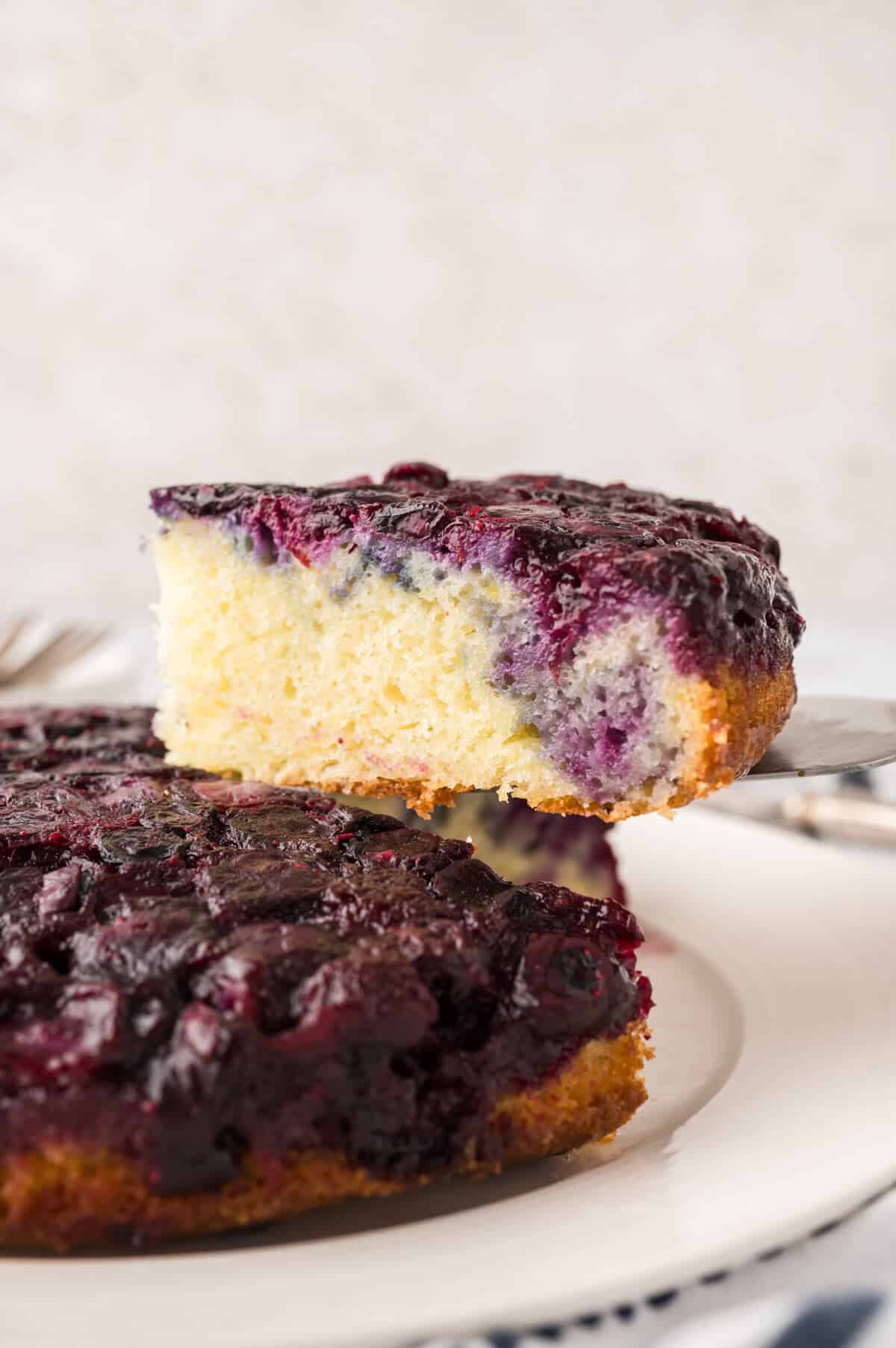 A slice of blueberry upside down cake on a spatula.