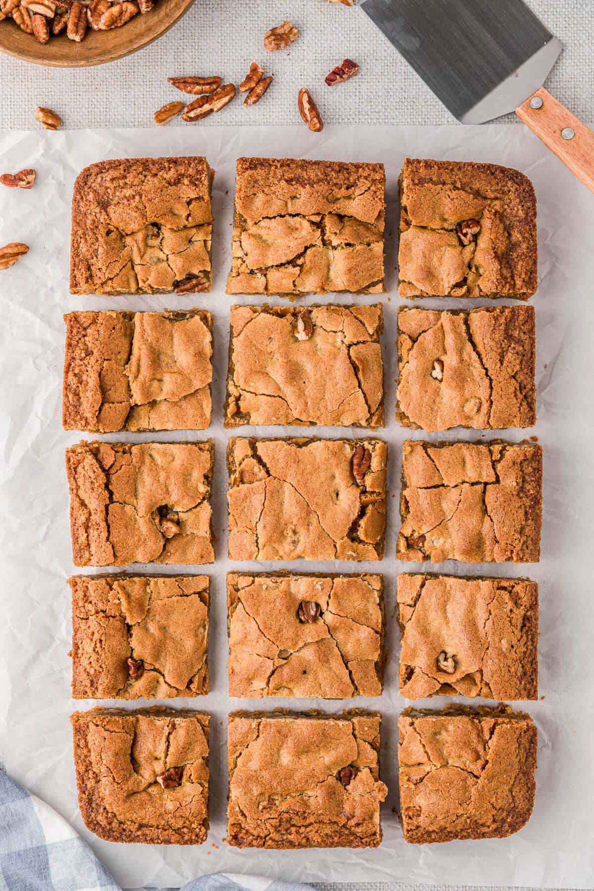 Butterscotch blondies cut on a piece of parchment paper.