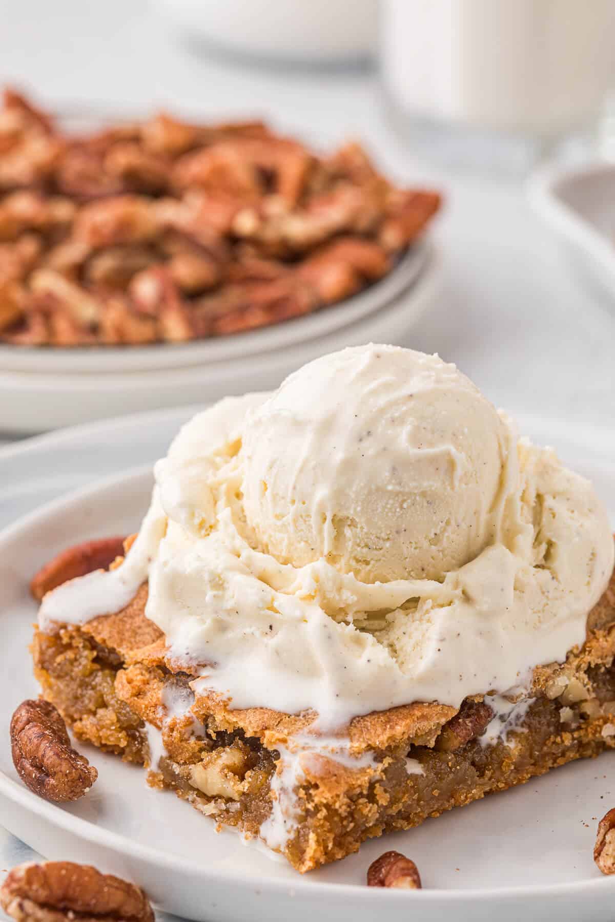 A butterscotch blondie topped with a scoop of vanilla ice cream.