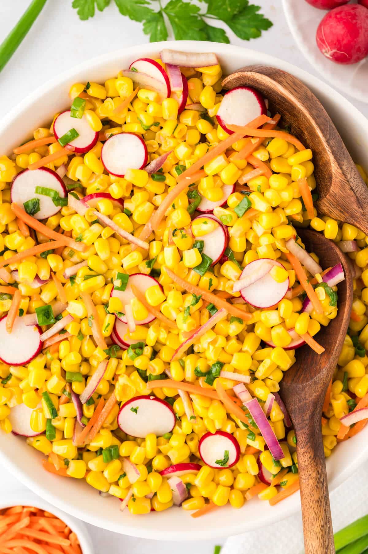 Corn Salad in a bowl with wooden spoons.