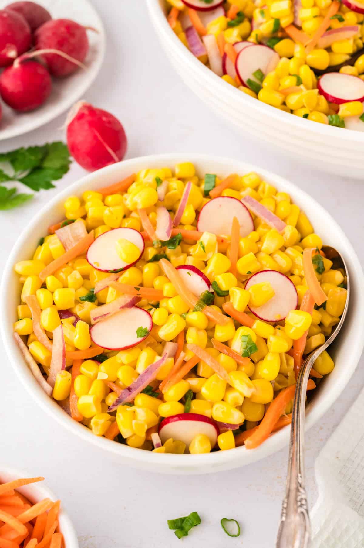 Corn salad in a bowl with a spoon.