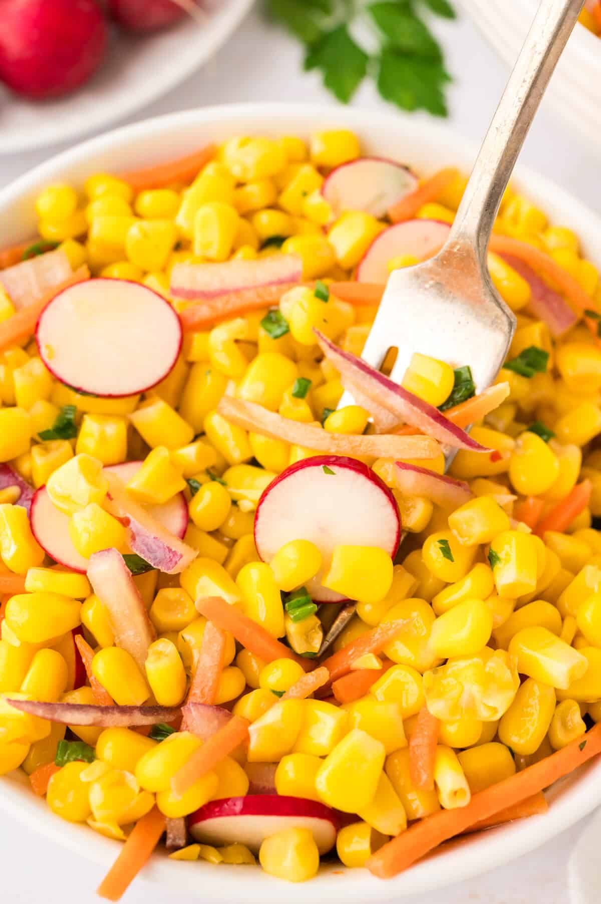 Corn salad in a bowl with a fork.