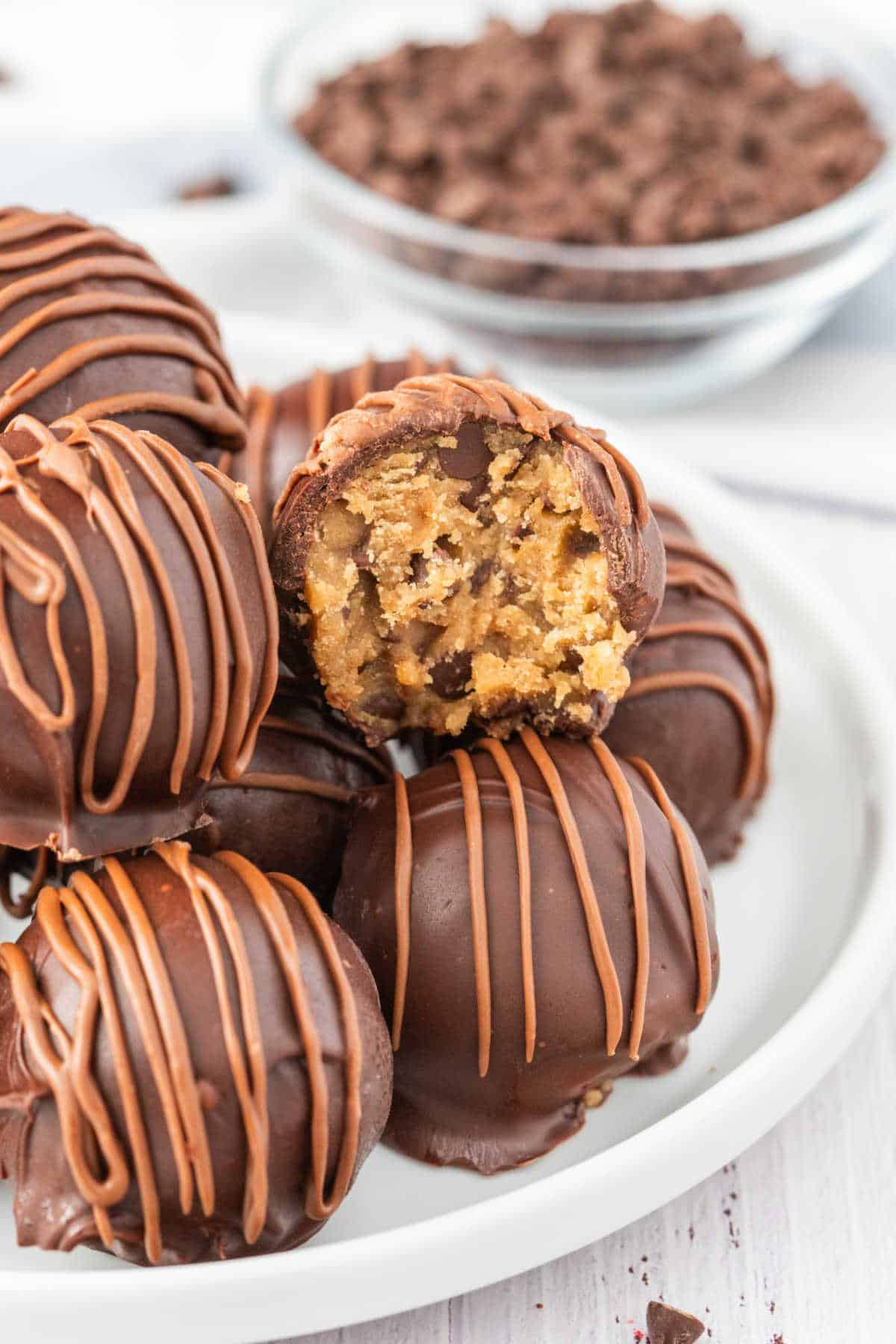 Cookie dough truffles on a plate with a bite out of one of them.