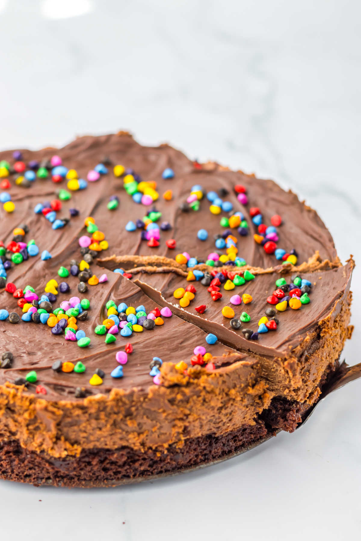 Cosmic brownie cheesecake with a slice cut.