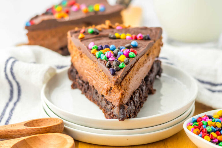 A slice of Cosmic Brownie Cheesecake on a plate.