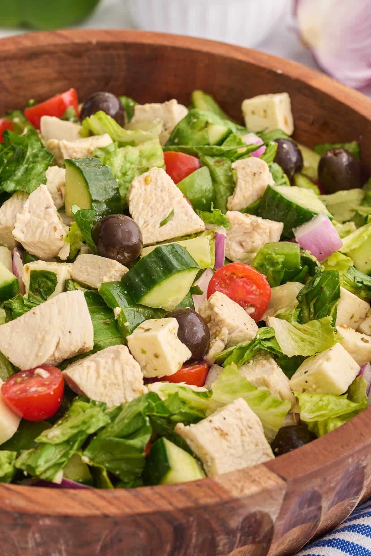 Greek chicken salad in a wooden bowl.