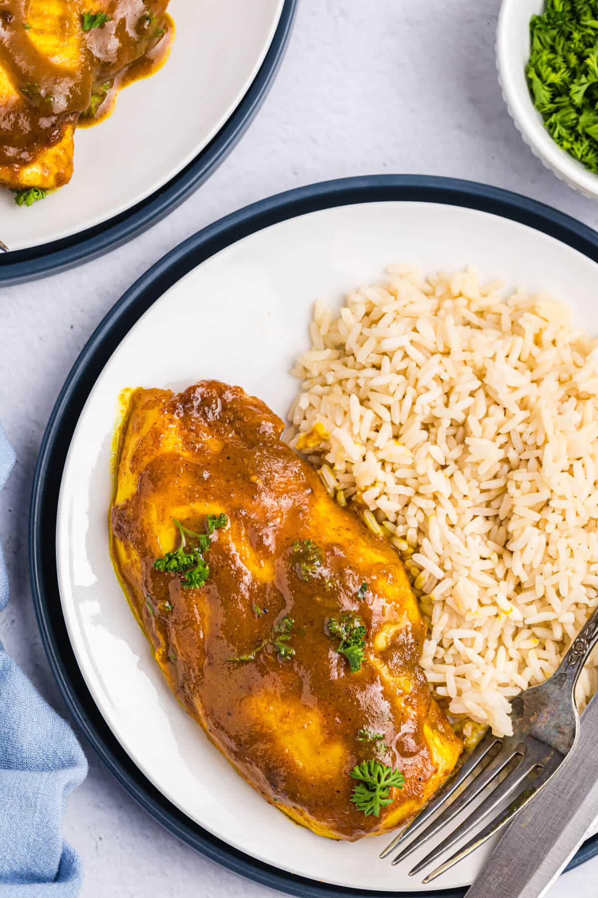 Honey curried chicken on a plate with white rice.