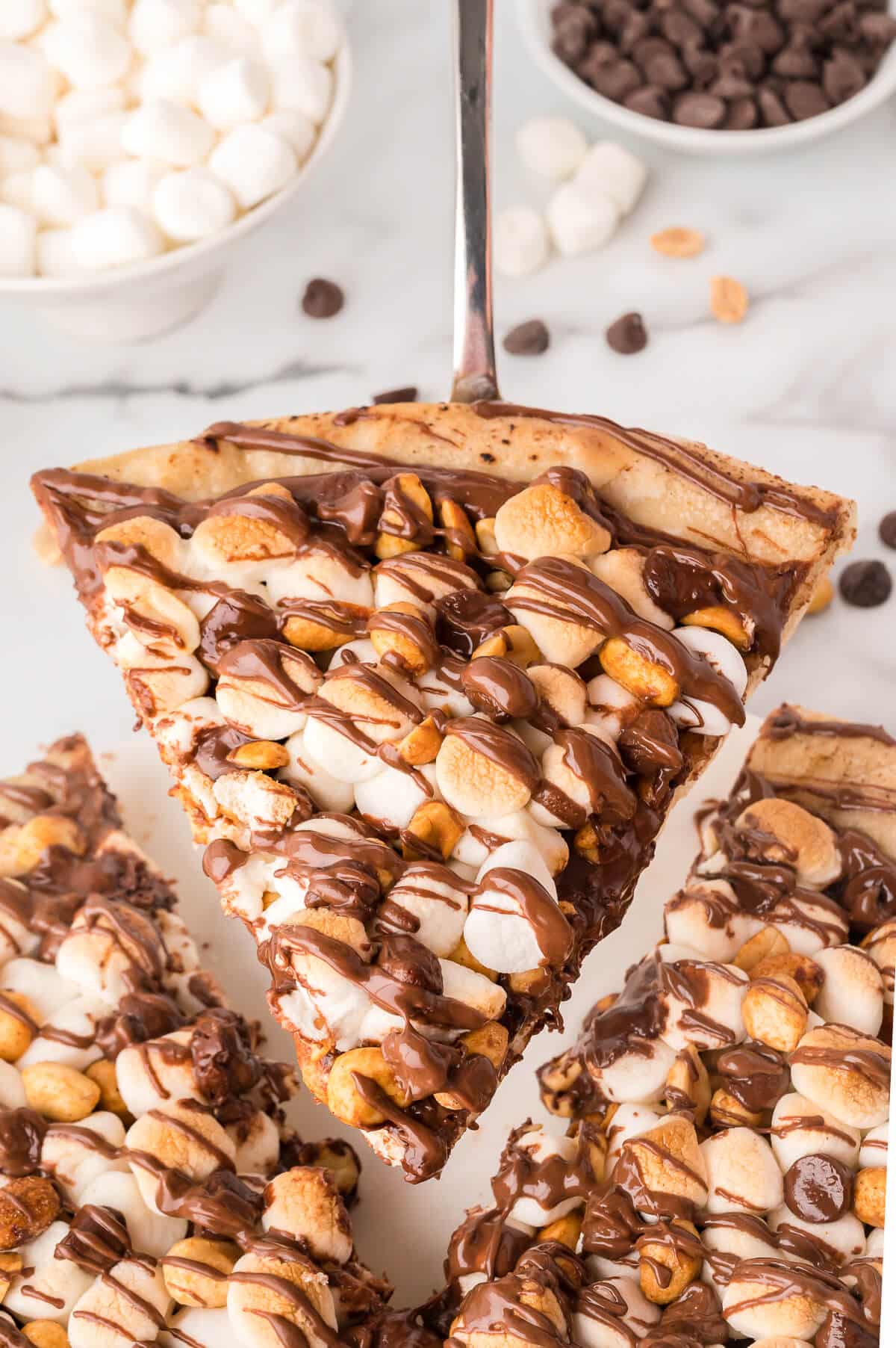 A slice of rocky road pizza on a spatula. 