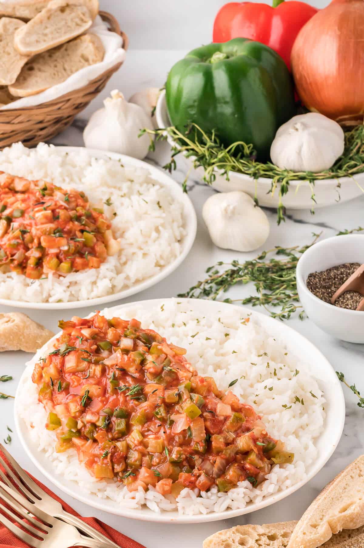 Spanish chicken on a bed of rice on a plate.