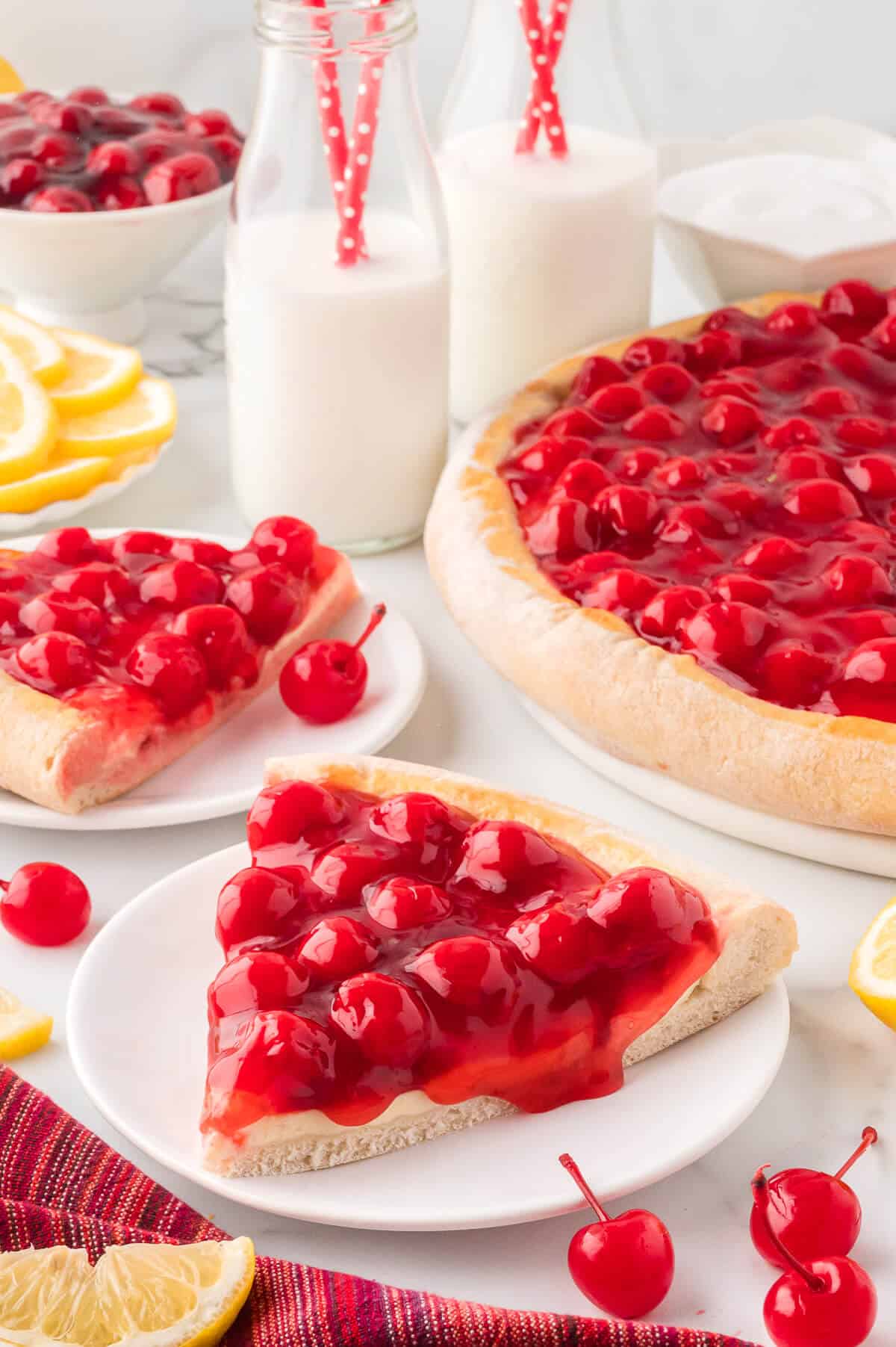 A slice of cherry cheesecake pizza on a plate.