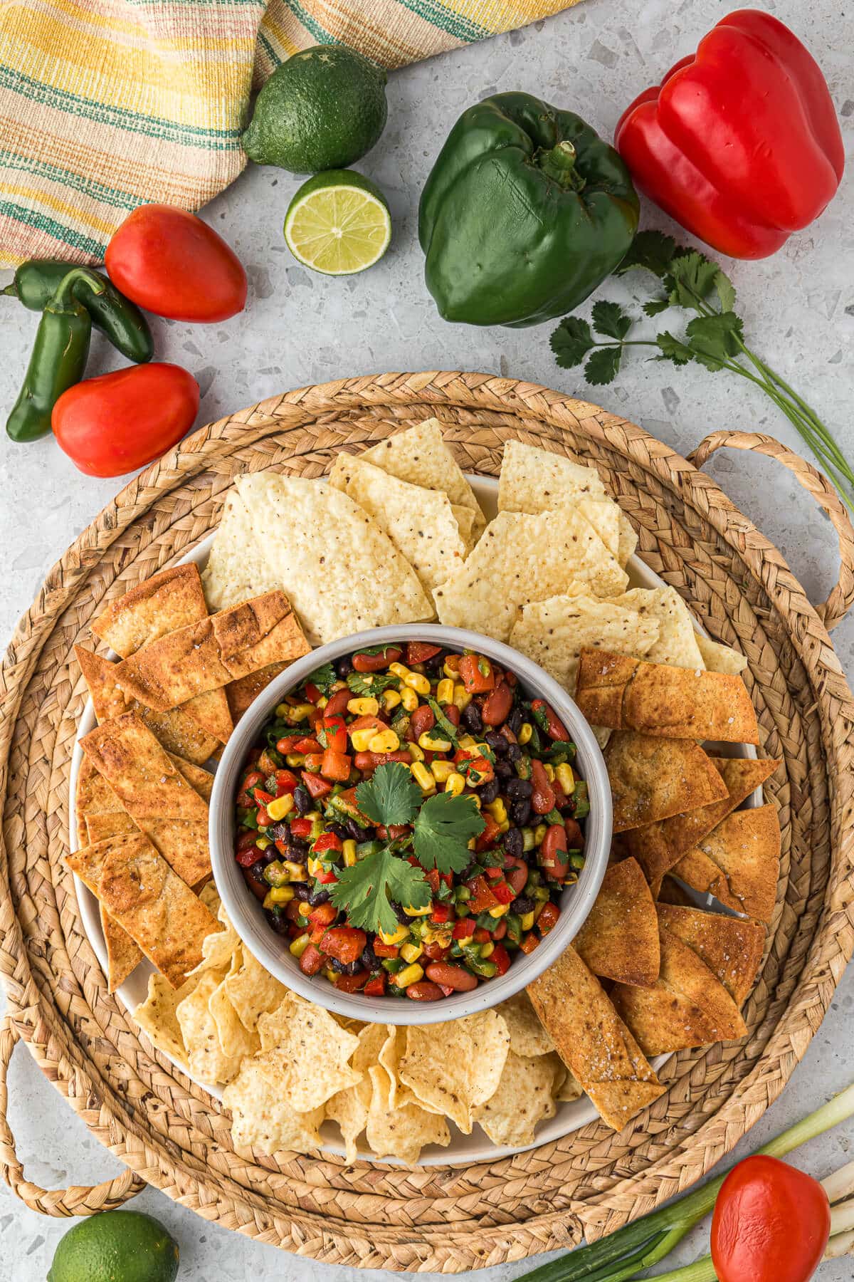 Cowboy caviar on a platter surrounded by chips.