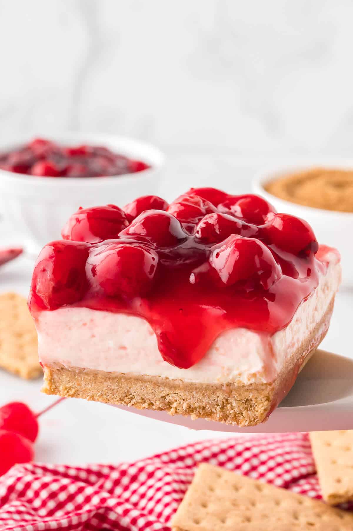 A slice of cherry cheesecake on a serving spoon.