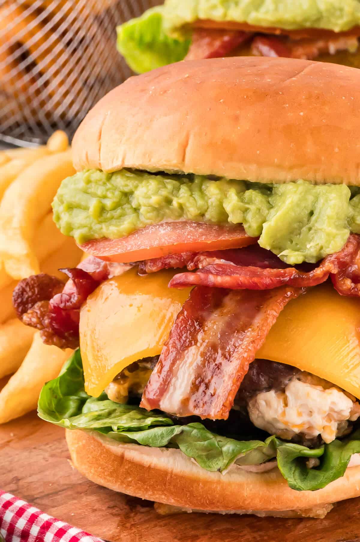 A cream cheese stuffed jalapeno burger on a wooden cutting board.
