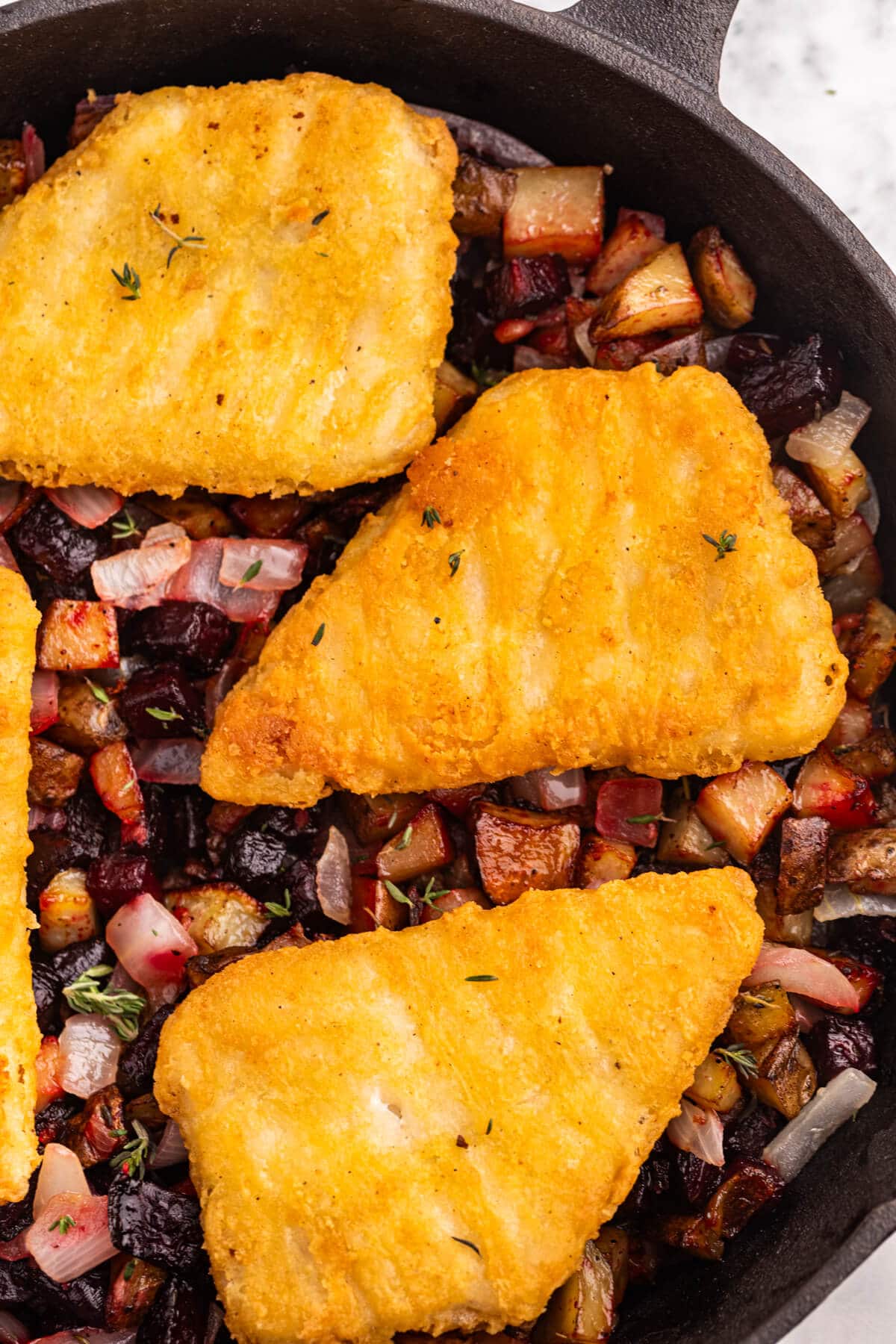 Fish with Beet and Potato Hash in a pan.