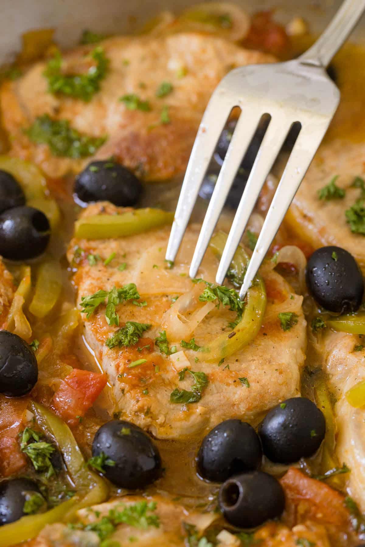 
Savory pork chops in a pan with a fork.