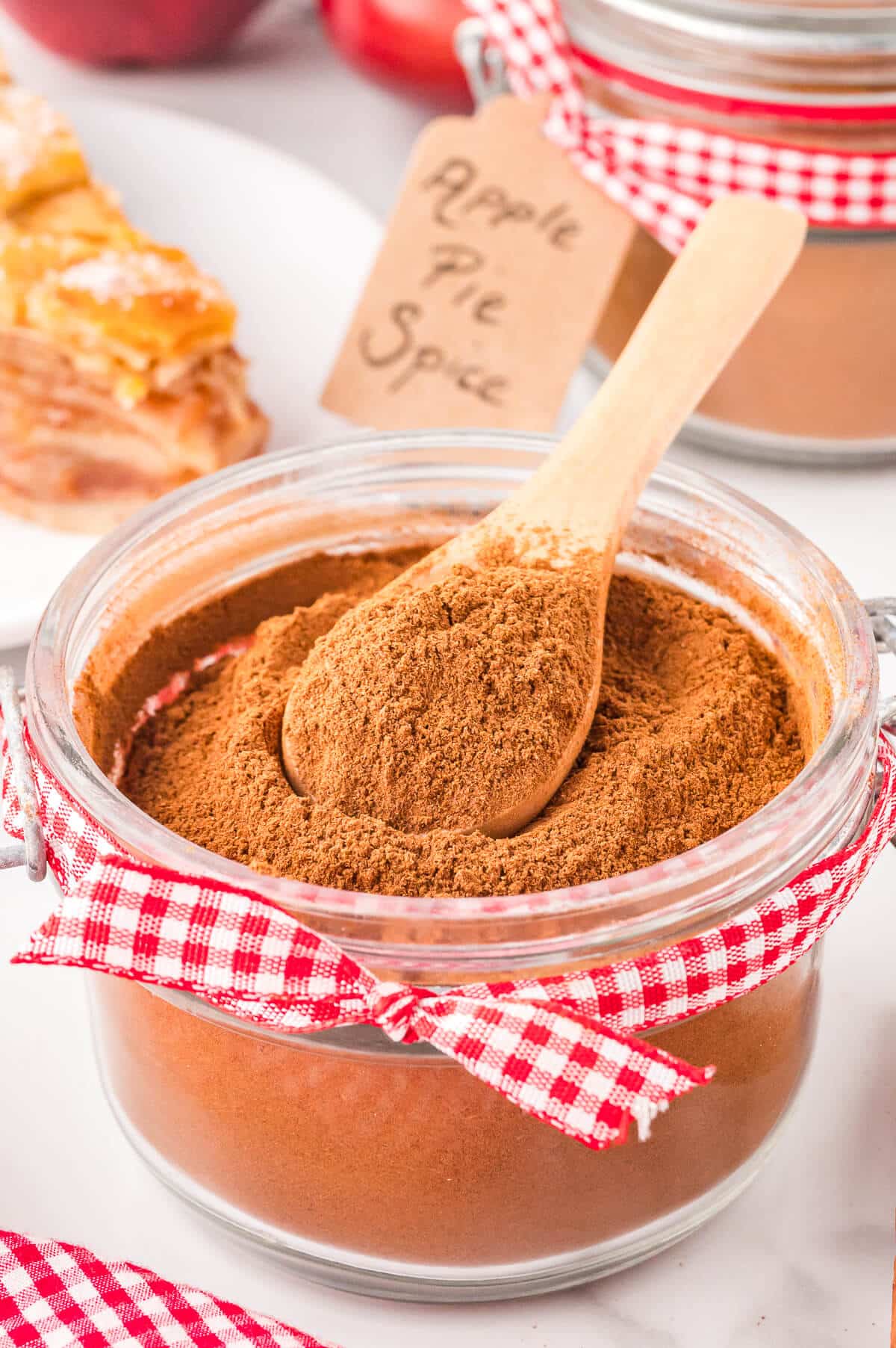 Apple pie spice in a jar with a spoon.