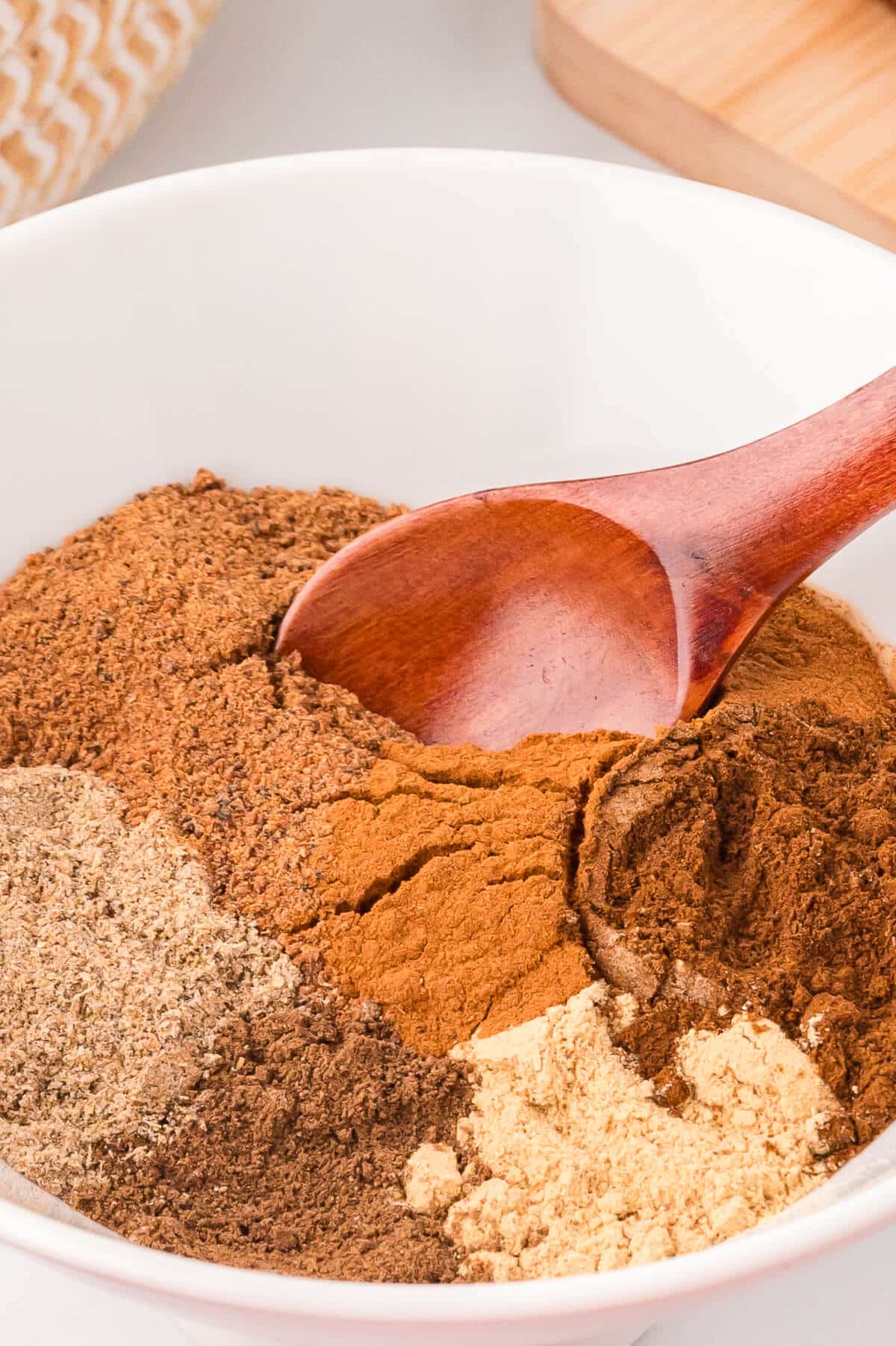 Spices on a plate with a wooden spoon.