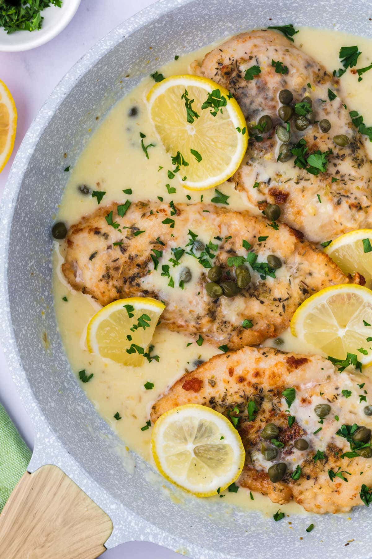 Lemon chicken piccata in a pan. 