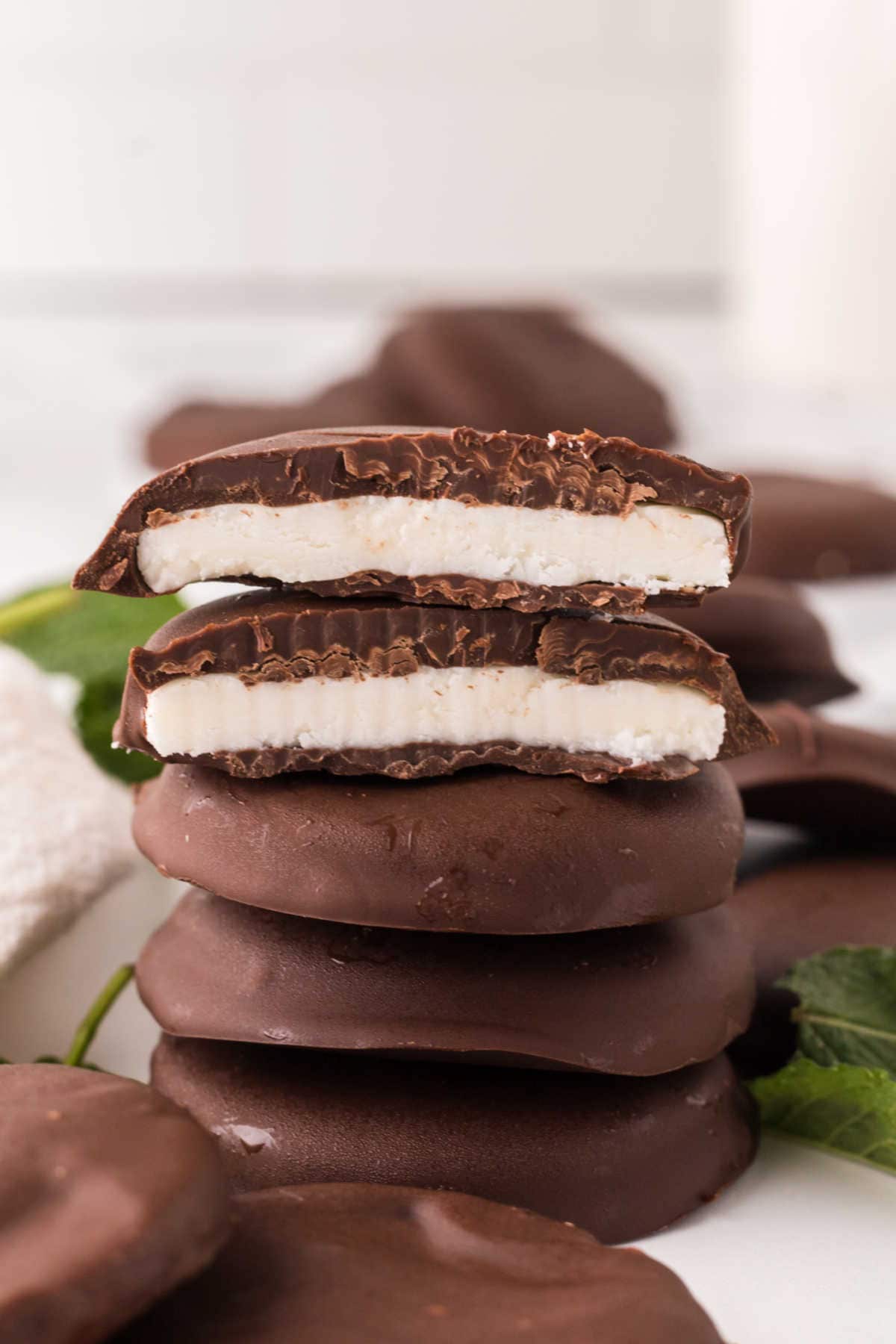 A stack of homemade peppermint patties with the top two cut in half.