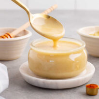A spoon drizzling the recipe in a jar.