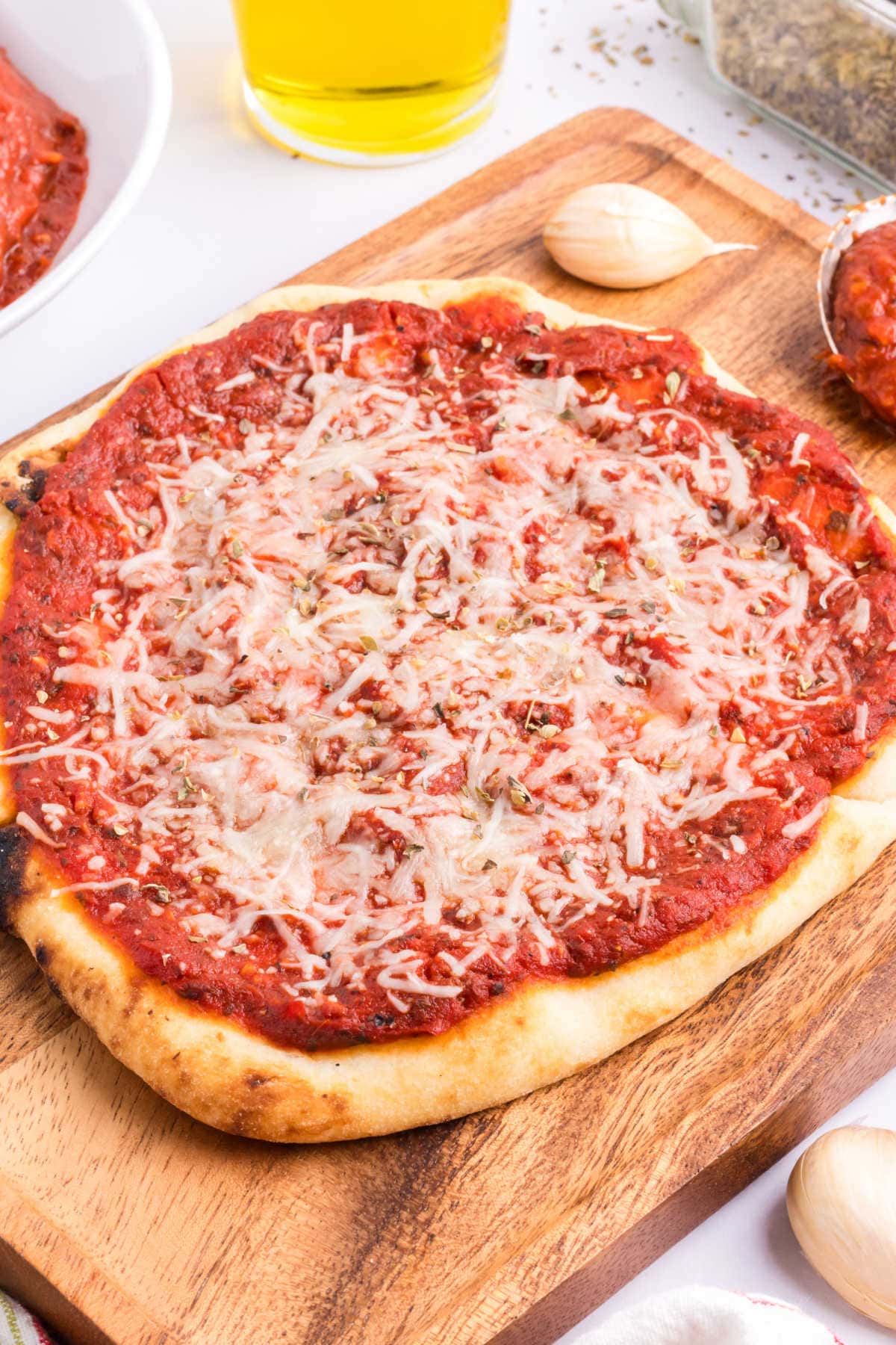 A pizza on a wooden cutting board.