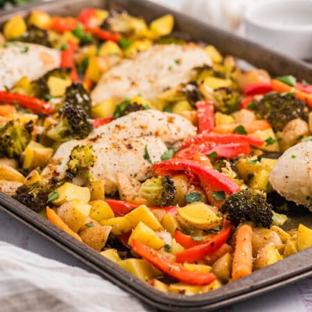 A sheet pan with chicken, vegetables and potatoes