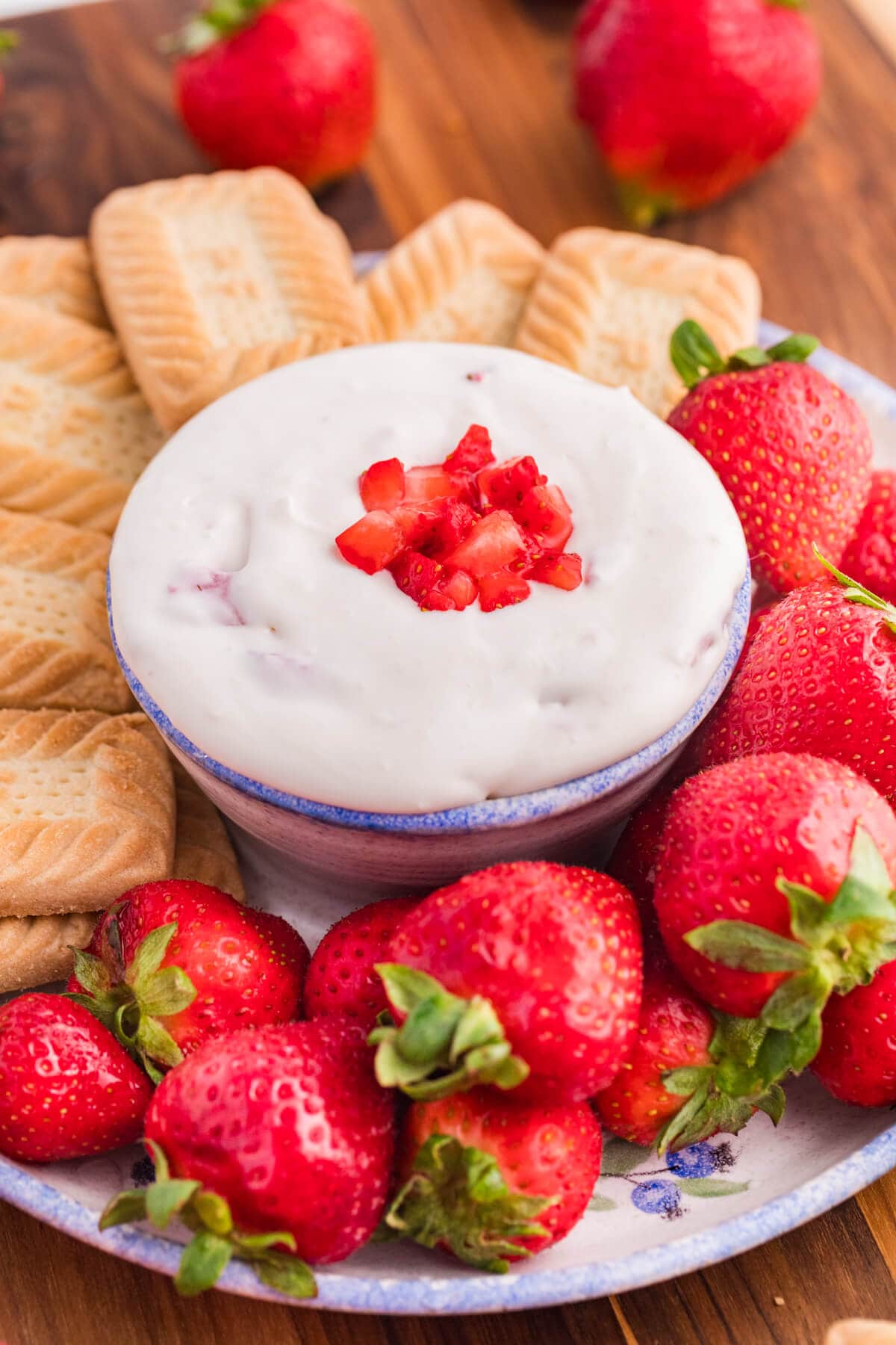 Strawberry cheesecake dip surrounded by cookies and strawberries.