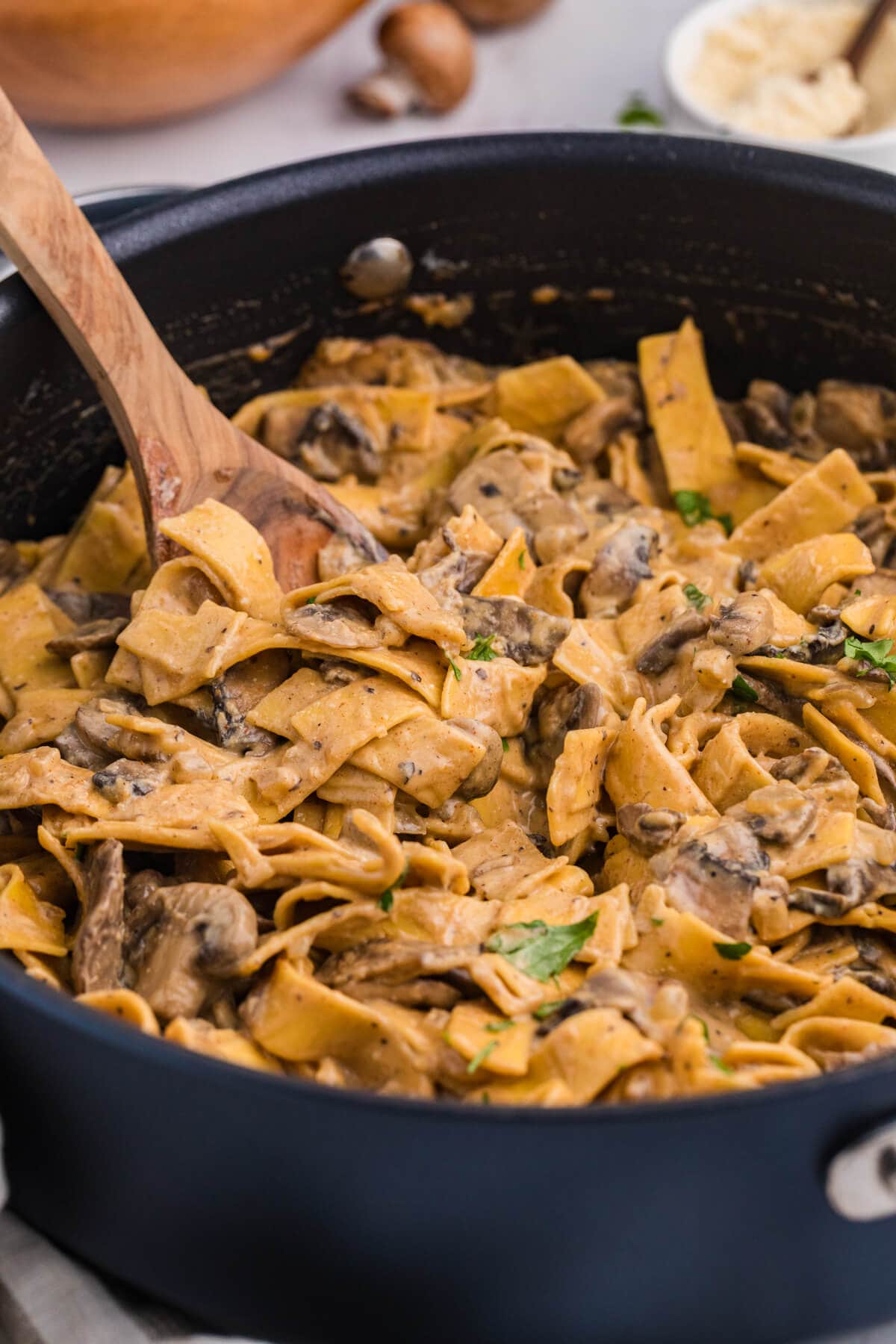 The recipe in a skillet with a wooden serving spoon.