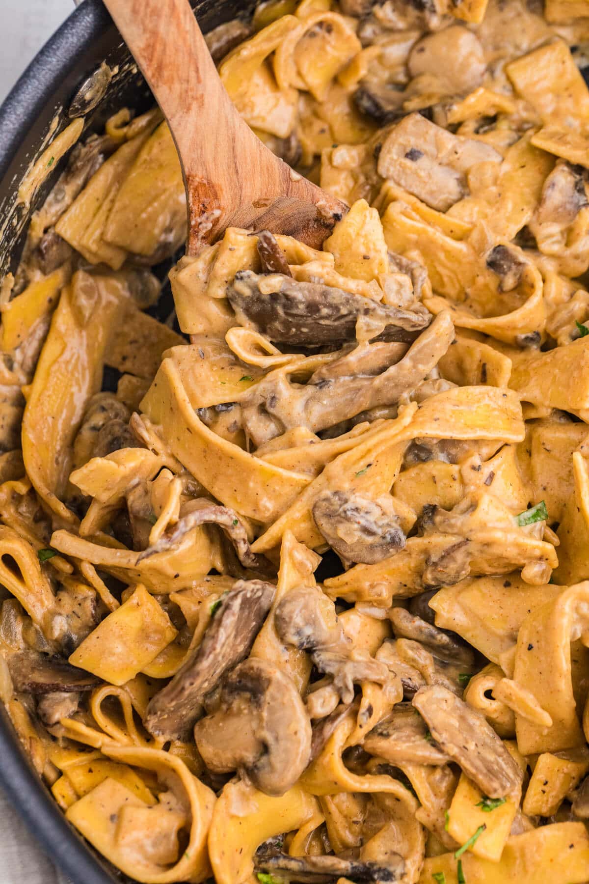 The recipe in a skillet with a wooden serving spoon.