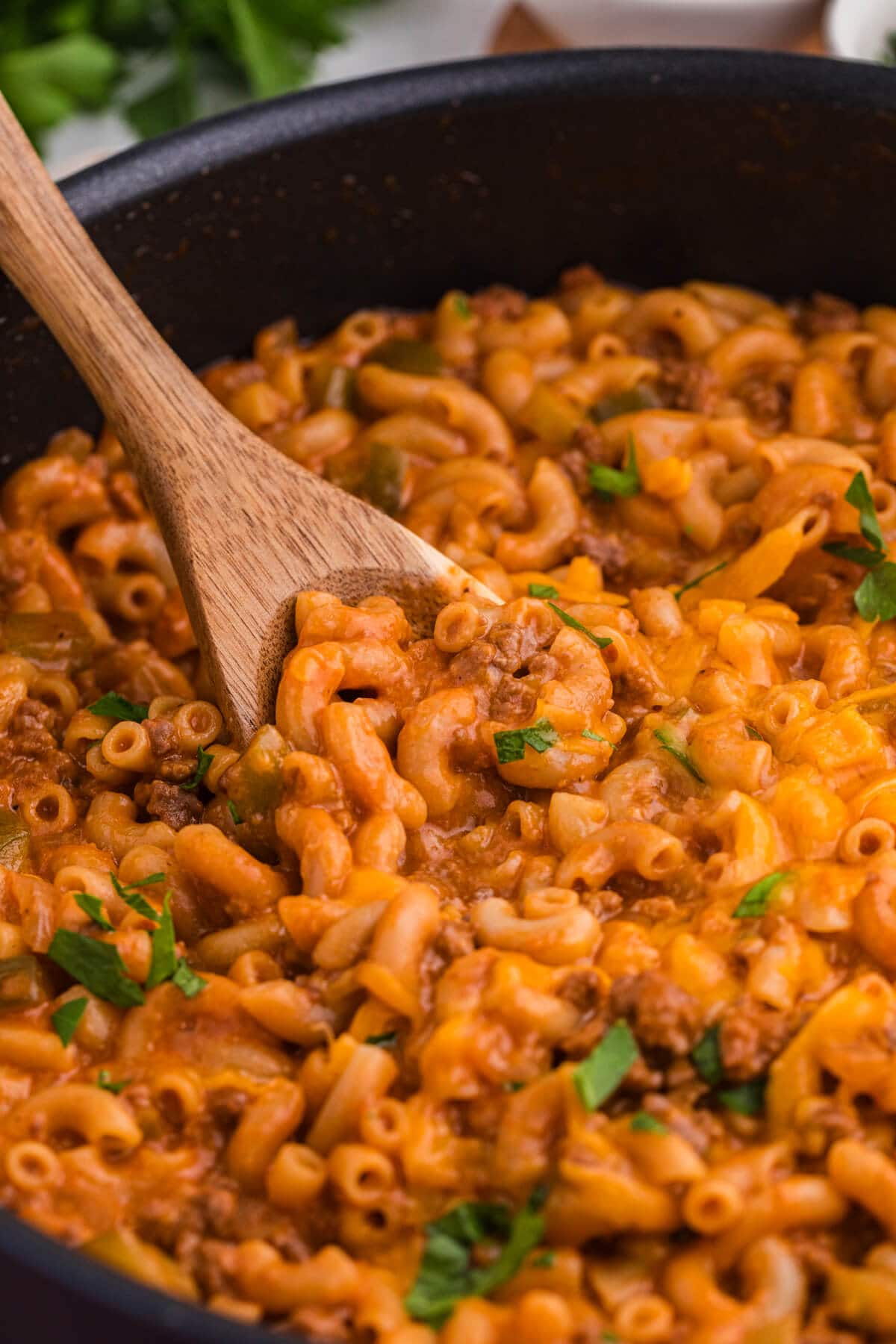 The recipe in a skillet with a wooden spoon.