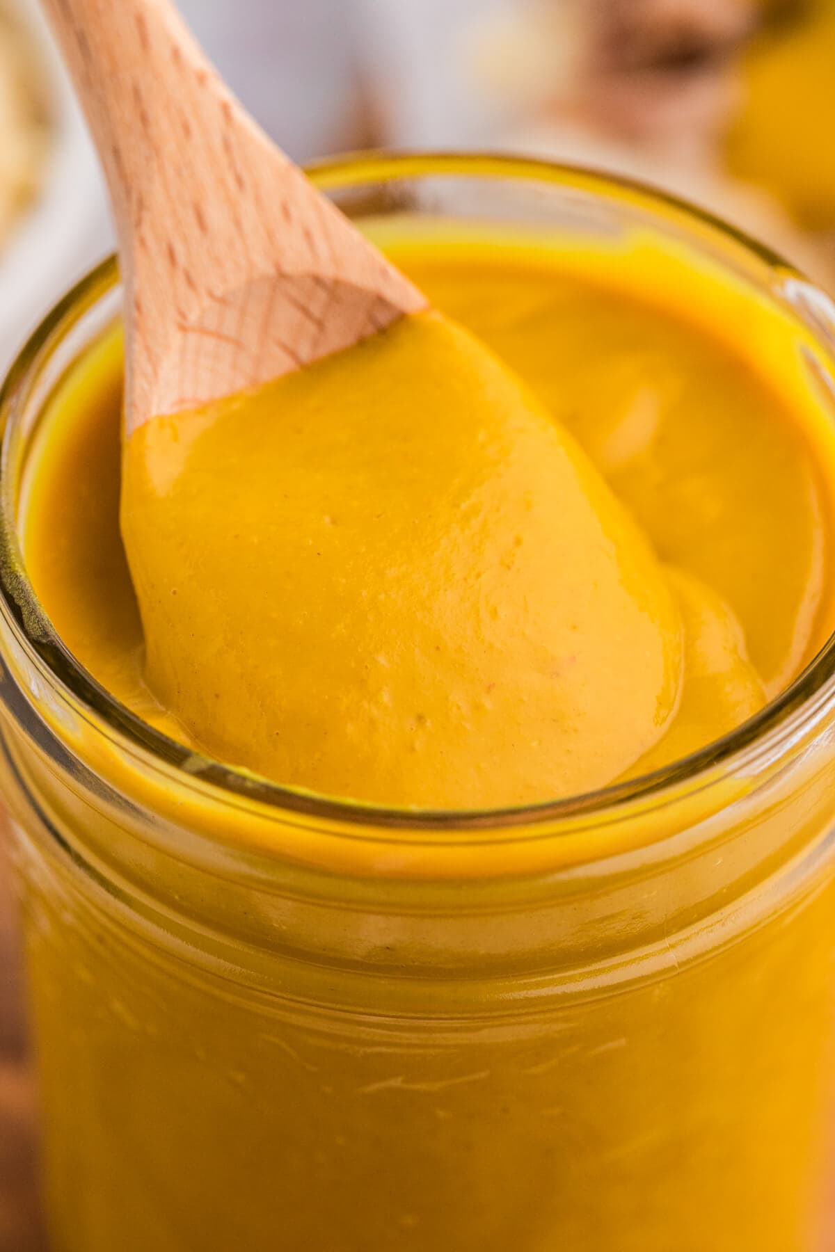 A wooden spoon in a jar of the recipe.