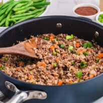 The recipe in a skillet in a wooden spoon.
