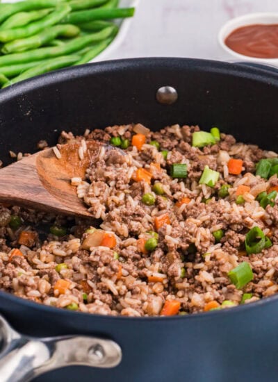 The recipe in a skillet in a wooden spoon.