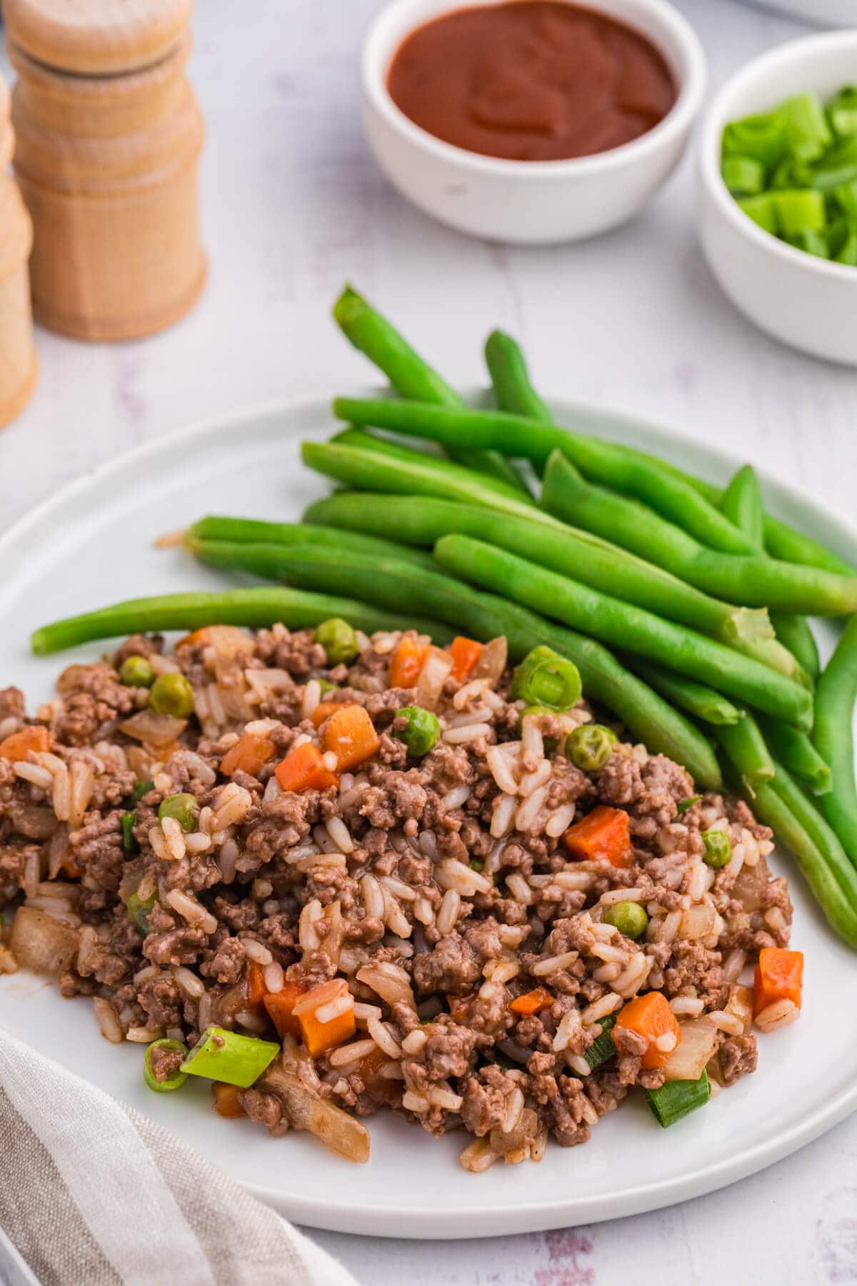 The recipe on a white plate with green beans.