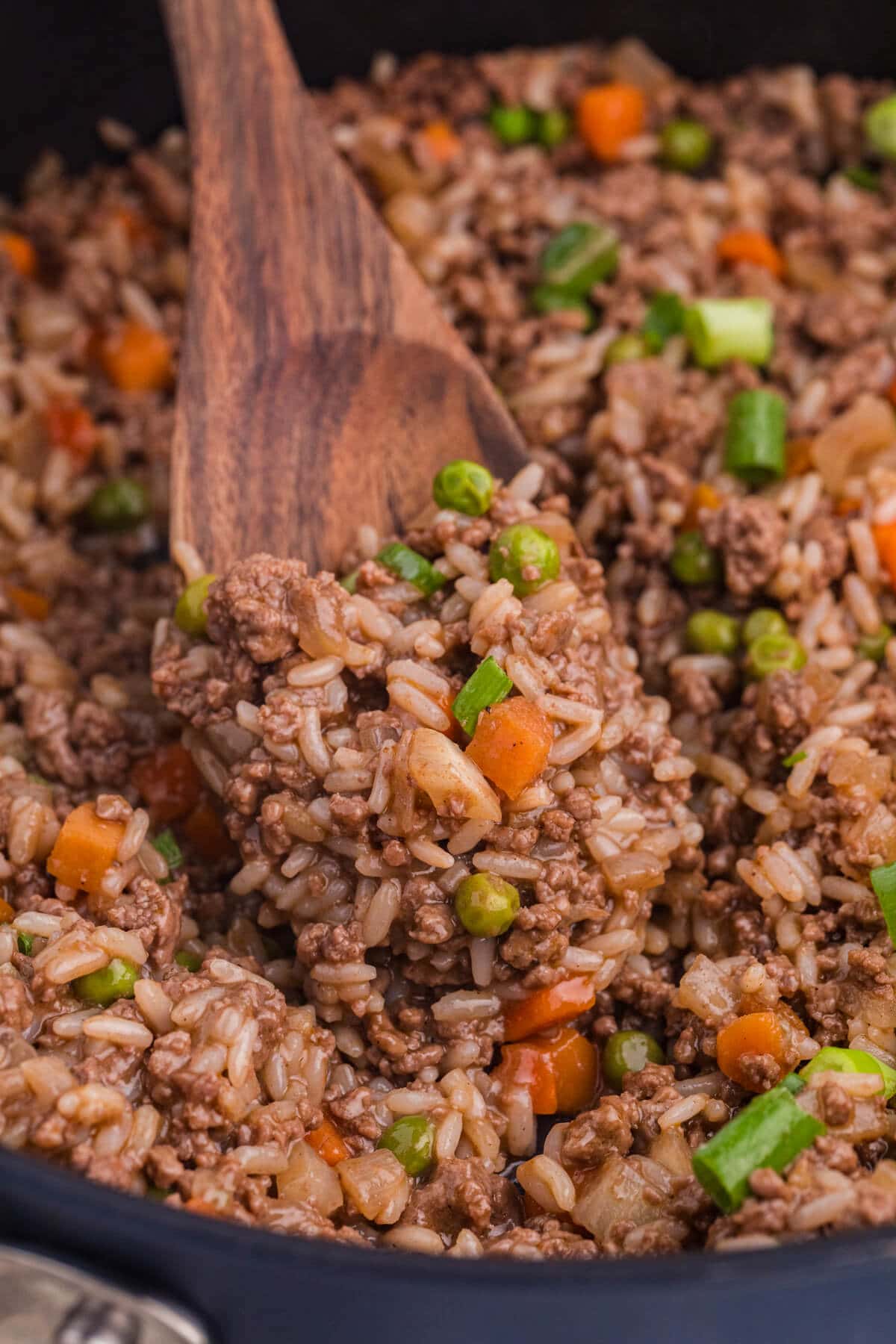 The recipe on a wooden spoon in a skillet.