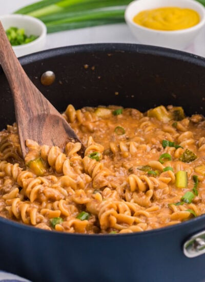 The recipe in a dark pan with a wooden spoon.