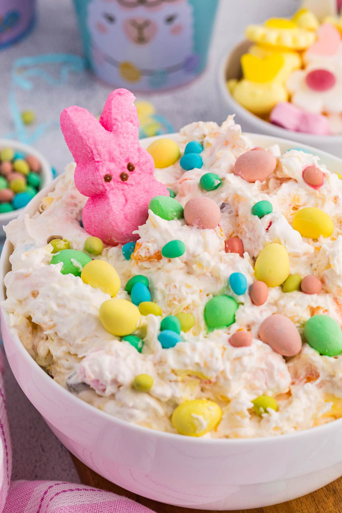 Close-up Easter fluff dessert with pastel eggs and pink marshmallow bunny.