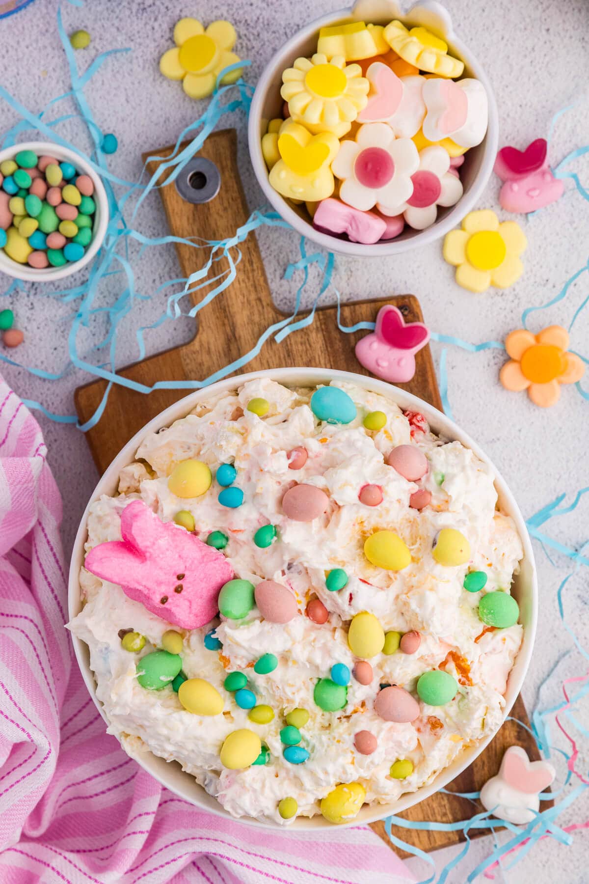 Overhead Easter fluff salad with pastel candy eggs, marshmallow bunny, and spring decorations.