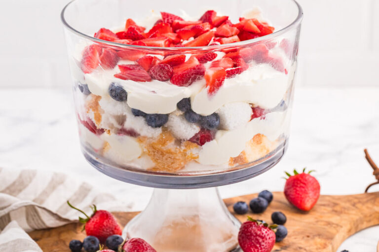 Angel Food Cake Trifle layered with fluffy cake, creamy vanilla filling, strawberries, blueberries, and raspberries in a clear glass trifle bowl.