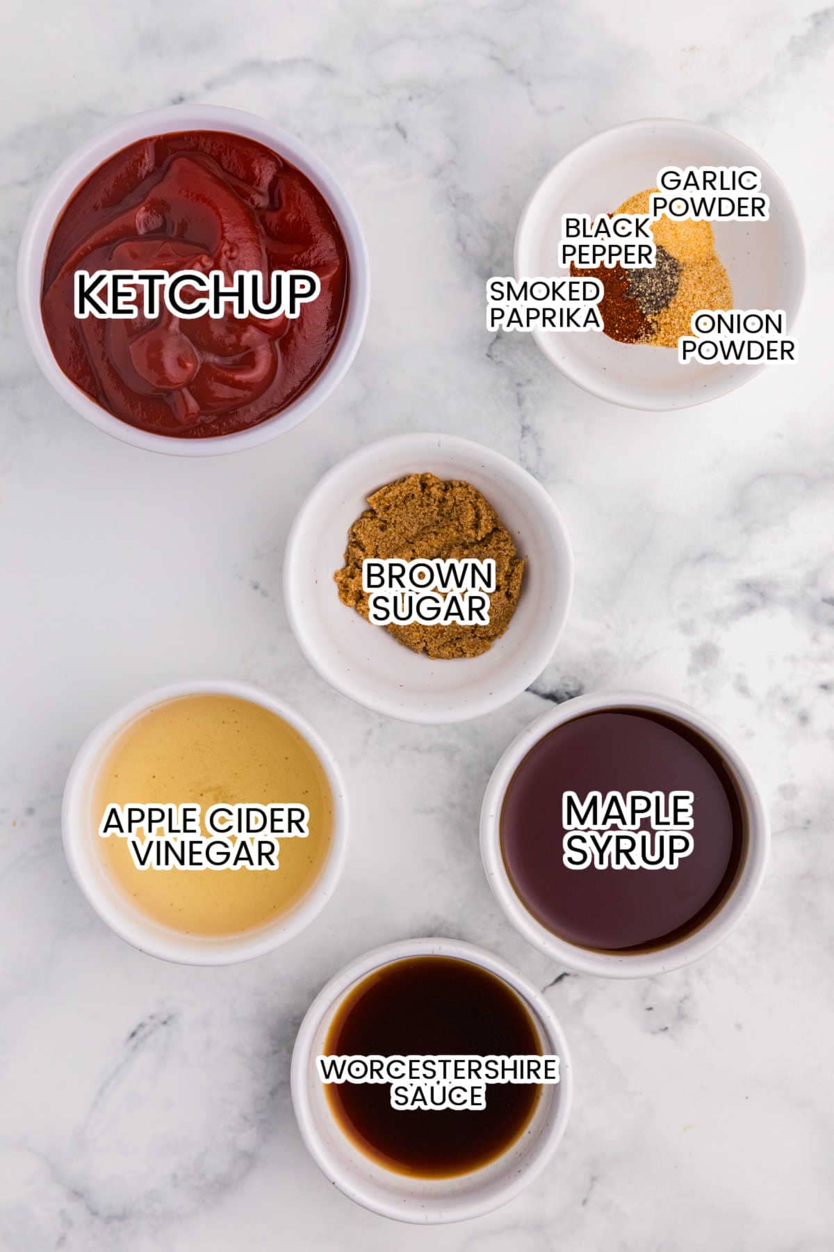 Ingredients for homemade maple BBQ sauce in labeled bowls, including ketchup, maple syrup, apple cider vinegar, Worcestershire sauce, brown sugar, and spices.