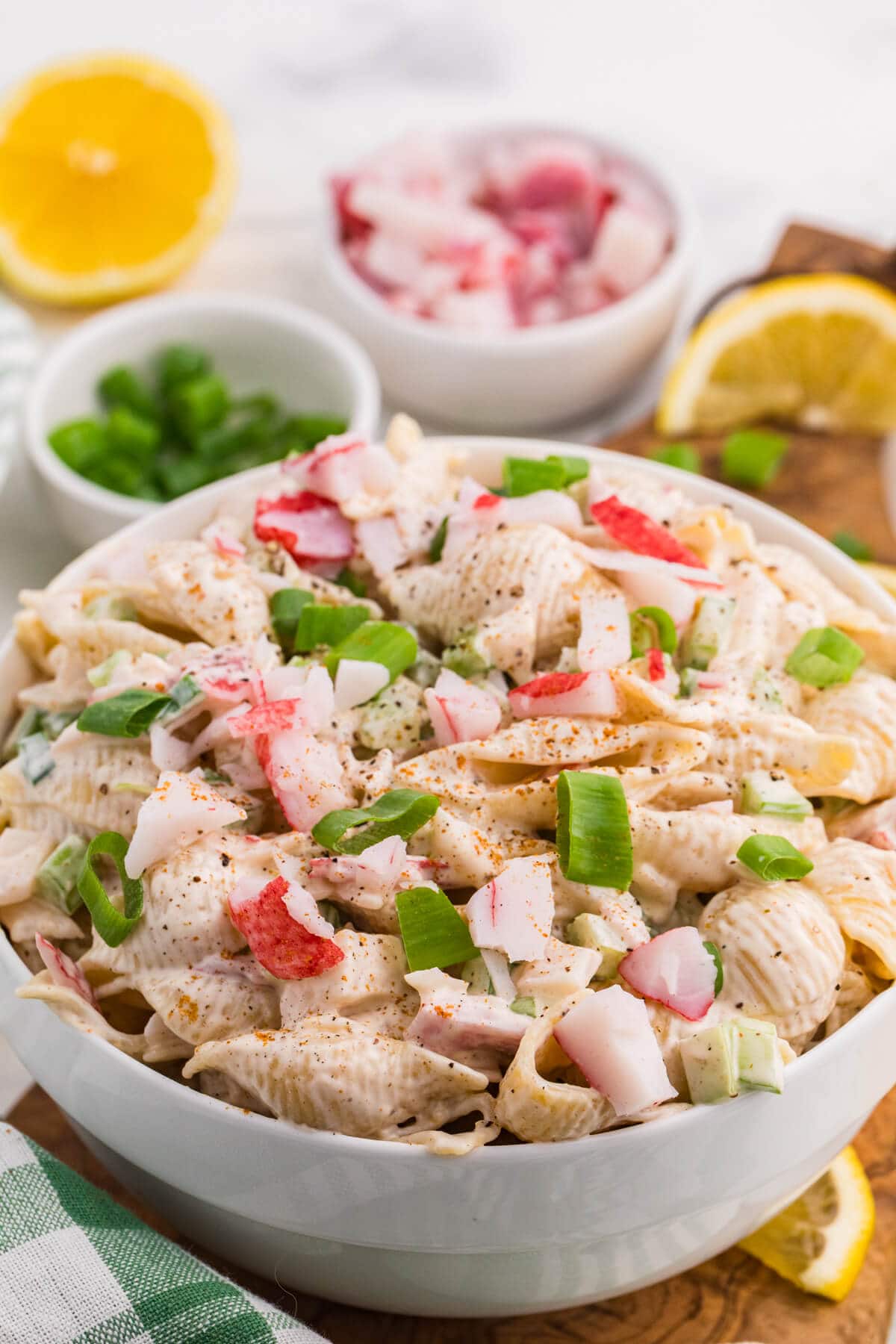 Creamy crab pasta salad with imitation crab, shell pasta, celery, and green onions in a serving bowl.