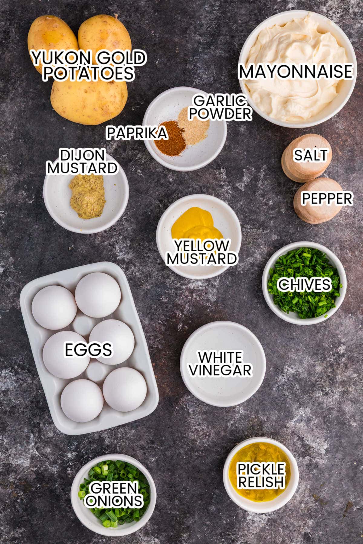 Ingredients for Deviled Egg Potato Salad including Yukon Gold potatoes, eggs, mayonnaise, yellow and Dijon mustard, vinegar, relish, green onions, chives, paprika, and seasonings.