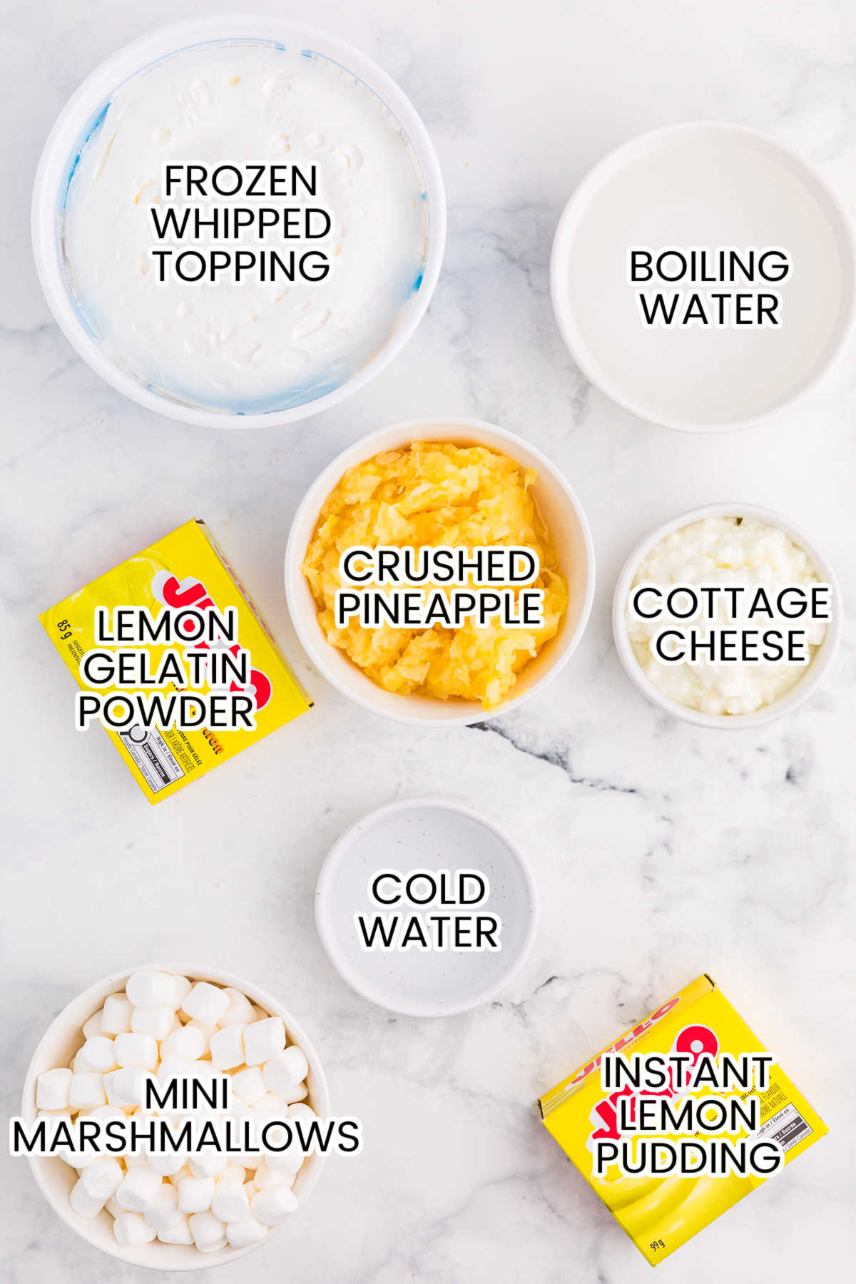 Ingredients for Lemon Fluff including lemon gelatin, instant lemon pudding, whipped topping, mini marshmallows, crushed pineapple, cottage cheese, boiling water, and cold water.