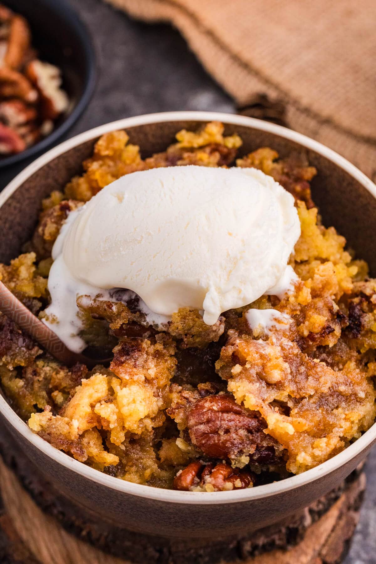 Maple Syrup Dump Cake with pecans topped with a scoop of vanilla ice cream.