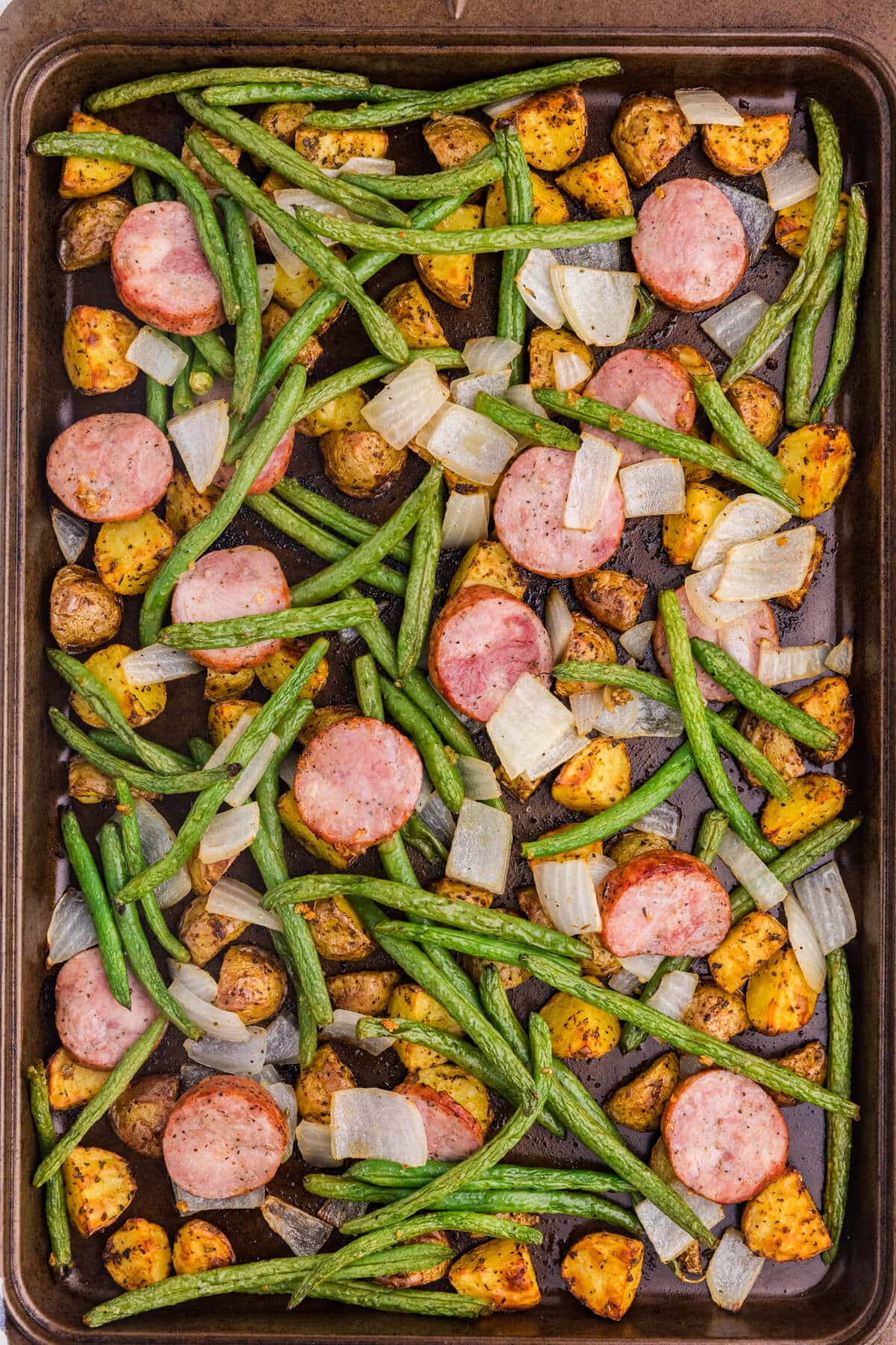 Sheet pan sausage, potatoes and green beans with roasted kielbasa, baby potatoes, green beans, and onion.