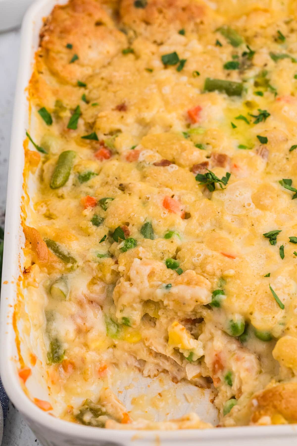 TikTok Chicken Cobbler in a white baking dish with creamy shredded chicken, mixed vegetables, and a golden Cheddar Bay biscuit topping.