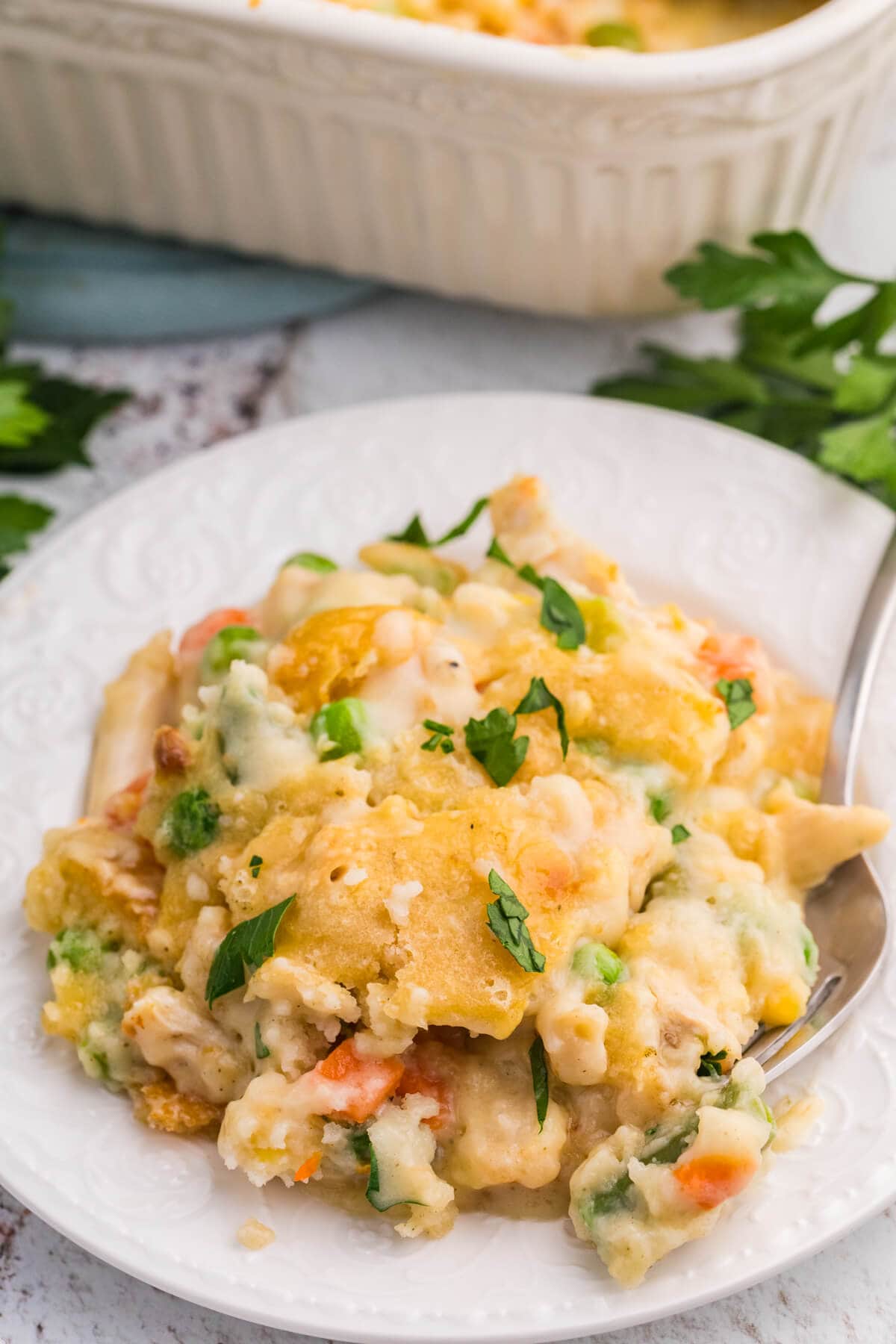 Close-up of TikTok Chicken Cobbler with creamy chicken and mixed vegetables topped with golden Cheddar Bay biscuits and fresh parsley.
